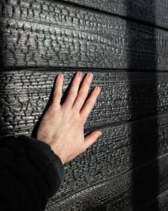 Hand touching a Shou Sugi Ban wall