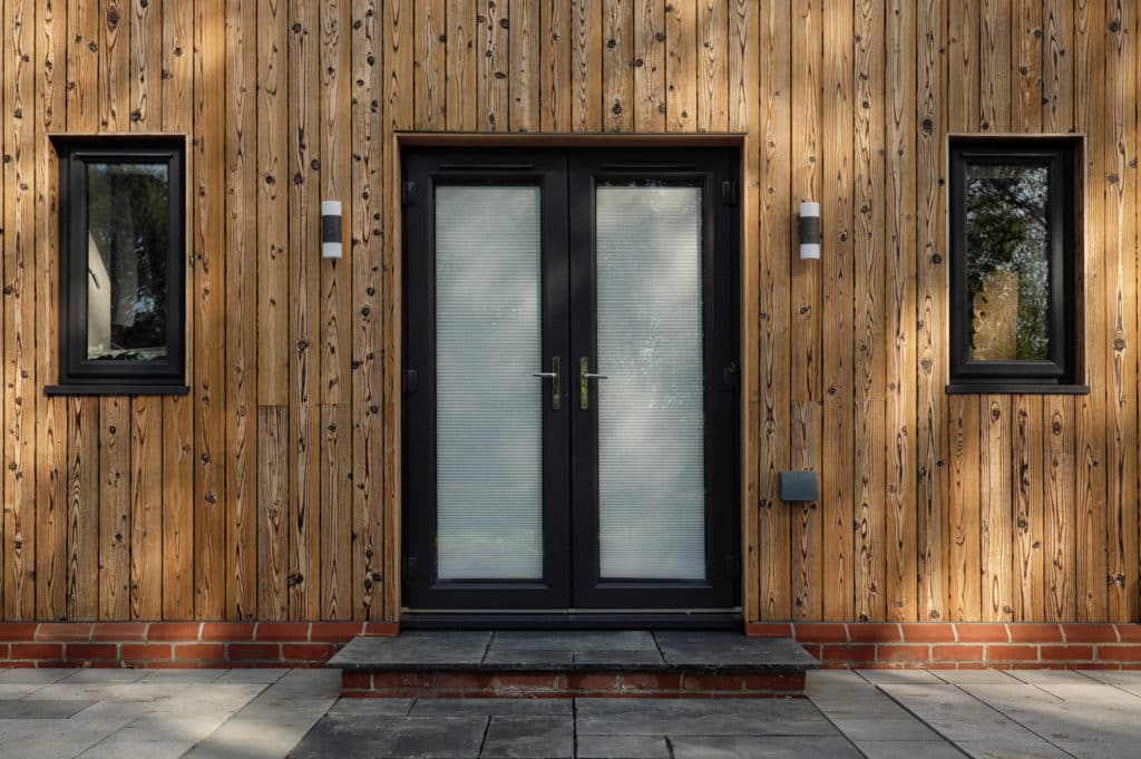 Entrance door of a house equipped with light wood as a facade material