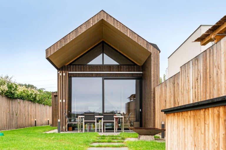 Light brown house with pointed roof and large window fronts