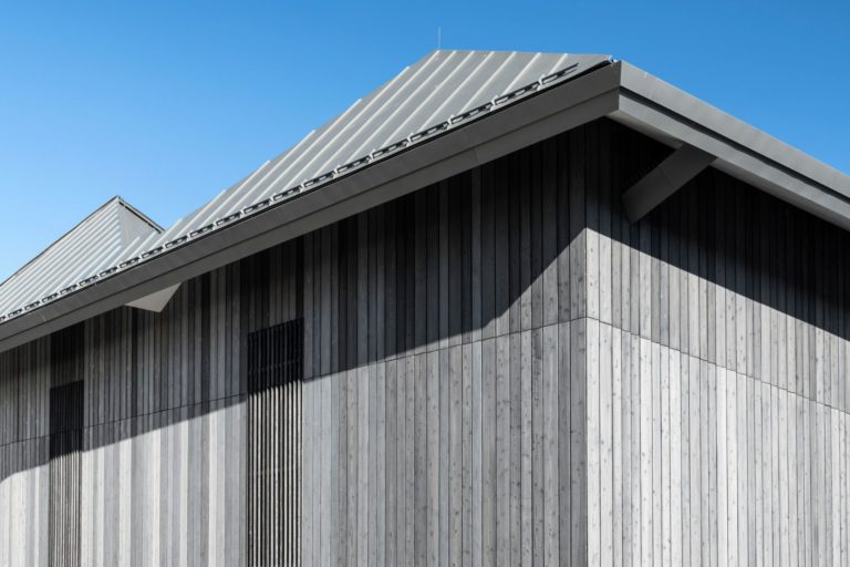 Building with light grey wood and blue sky