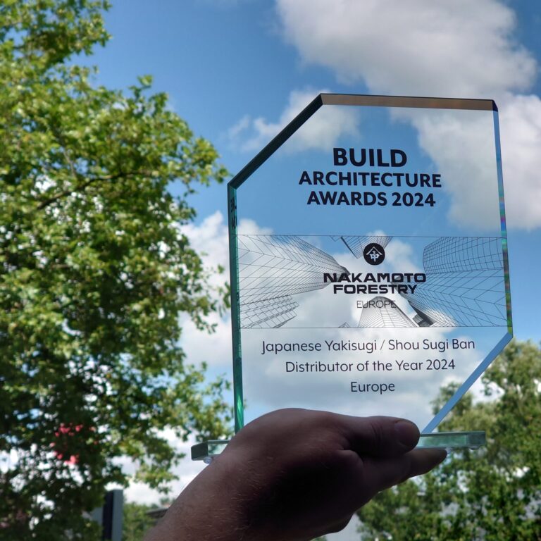 Hand holding Nakamoto Forestry Award 2024 against blue sky